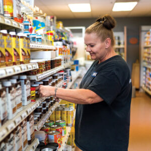 A paint store employee stocking shelves